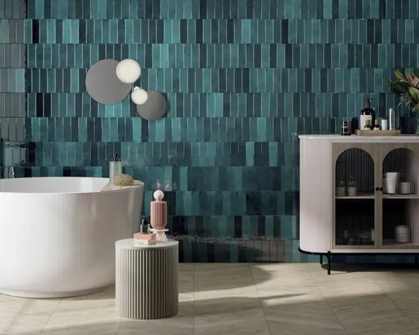 Une grande salle de bain moderne avec baignoire îlot, carrelage mural bleu sarcelle texturé et meuble de rangement élégant.