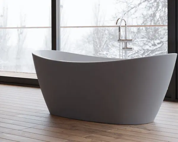 Une baignoire moderne dans une chambre, avec une grande fenêtre offrant une vue sur un paysage enneigé. Parfait pour un moment de détente.
