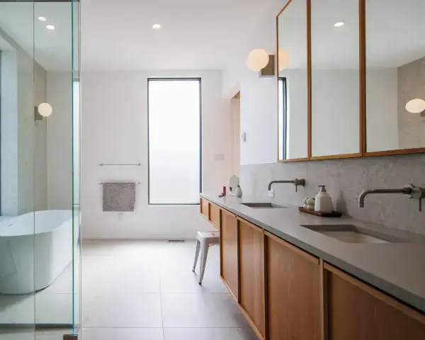 Plan salle de bain rectangulaire moderne avec baignoire, double vasque et rangements en bois.
