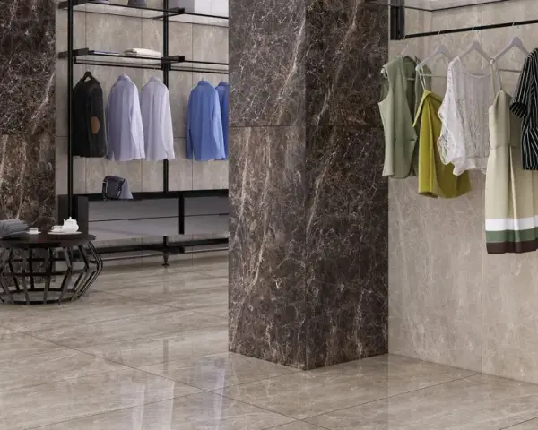 Un dressing moderne avec des vêtements suspendus, un fauteuil noir et un sol en lappato carrelage aux tons taupe.