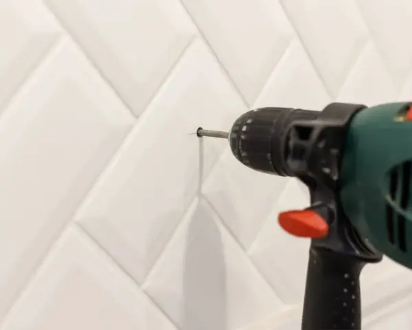Une perceuse est utilisée pour percer le carrelage de la salle de bain.