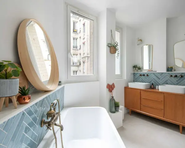Élégante salle de bain moderne avec baignoire, double vasque sur meuble vintage et carrelage bleu en chevrons.