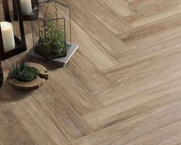 Sol en carrelage imitation bois, pose en chevron. Lanternes, bougies et plantes apportent une touche chaleureuse.