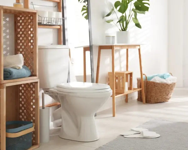 Toilette moderne et épurée, avec étagères en bois, paniers de linge et plantes vertes. Un style toilette invitant et fonctionnel.