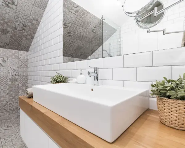 Une salle de bain moderne avec un lavabo rectangulaire blanc, un mur de carrelage métro blanc et un mur de carrelage décoratif gris. Une belle idée carrelage petite salle de bain.