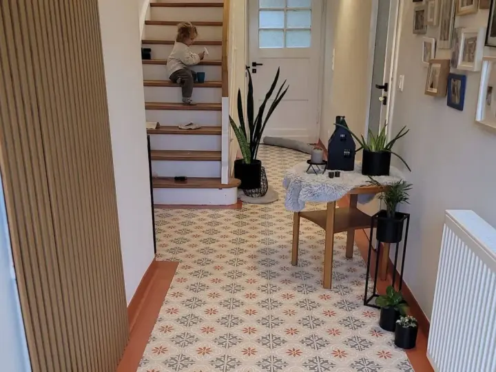 Un enfant sur les escaliers, un sol avec une peinture carrelage aux motifs floraux. La durée de vie de ce revêtement est impressionnante.