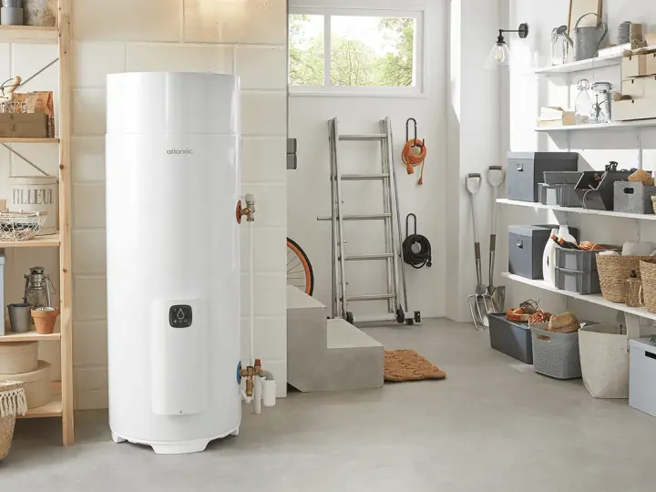 Un préparateur ECS Atlantic blanc trône dans un garage bien rangé, prêt à fournir de l'eau chaude.