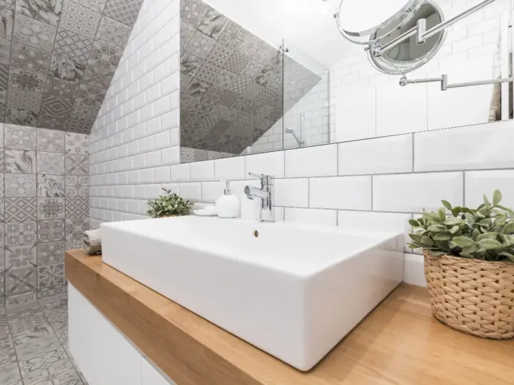 Une salle de bain moderne avec un lavabo rectangulaire blanc, un mur de carrelage métro blanc et un mur de carrelage décoratif gris. Une belle idée carrelage petite salle de bain.