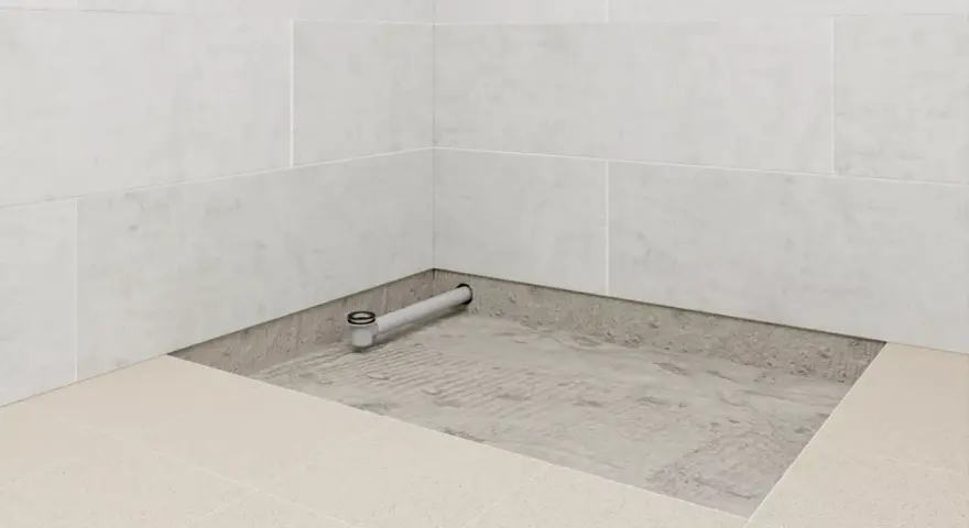Installation d'un receveur de douche entre trois murs, avec évacuation visible.