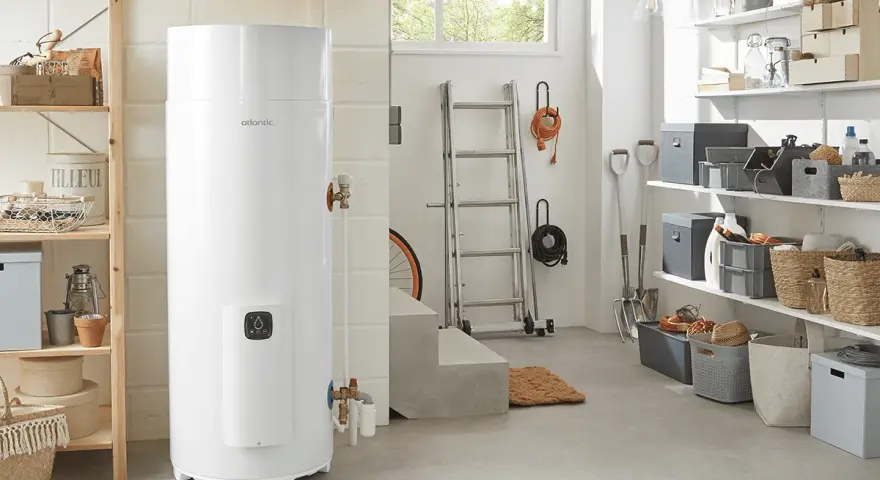 Un préparateur ECS Atlantic blanc trône dans un garage bien rangé, prêt à fournir de l'eau chaude.