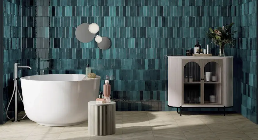 Une grande salle de bain moderne avec baignoire îlot, carrelage mural bleu sarcelle texturé et meuble de rangement élégant.