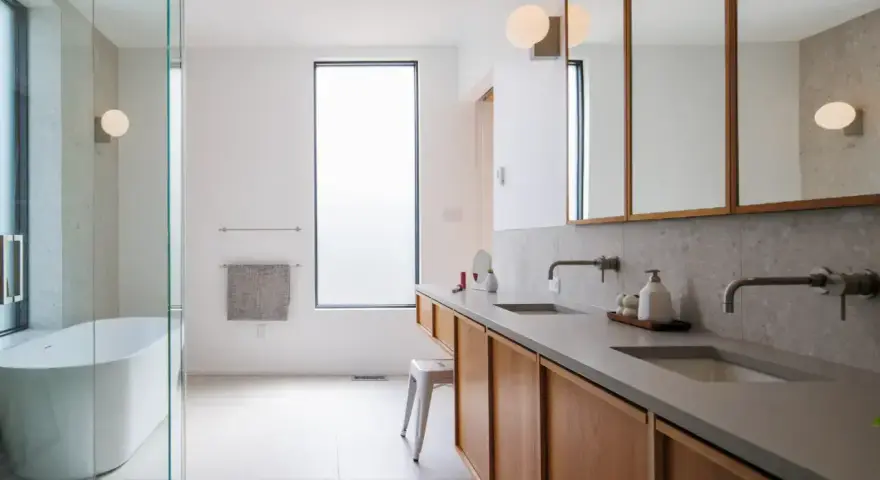 Plan salle de bain rectangulaire moderne avec baignoire, double vasque et rangements en bois.