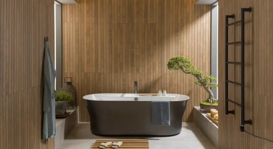 Une **salle de bain japandi** apaisante avec baignoire îlot, murs en bois, et un bonsaï.