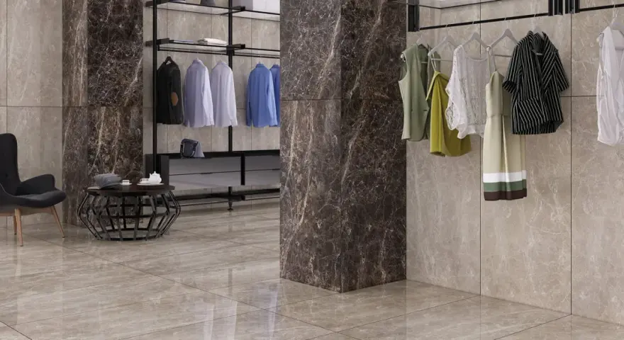 Un dressing moderne avec des vêtements suspendus, un fauteuil noir et un sol en lappato carrelage aux tons taupe.