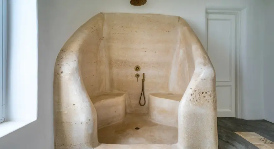 Douche à l'italienne en résine sculptée, avec bancs intégrés. Un inconvénient : le nettoyage peut être délicat.