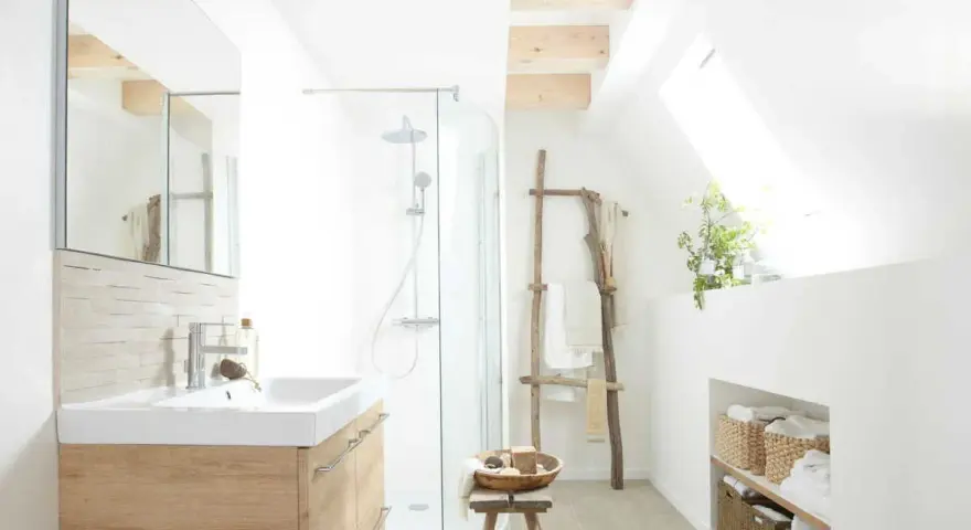 Salle de bain lumineuse avec douche, lavabo en bois clair et paniers de rangement. Un style de wet room épuré et naturel.