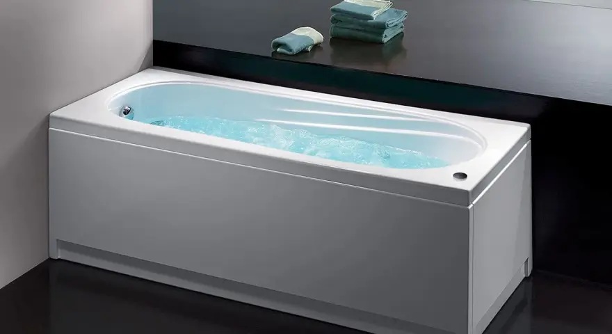Une baignoire moderne remplie d'eau bouillonnante, prête pour un moment de détente. L'idée de nettoyer baignoire semble loin avec ce bain invitant.