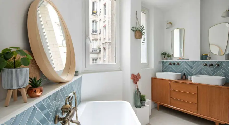 Élégante salle de bain moderne avec baignoire, double vasque sur meuble vintage et carrelage bleu en chevrons.