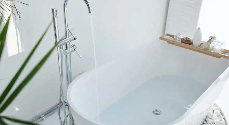 Baignoire moderne remplie d'eau, robinetterie chromée. Idéal pour changer la bonde baignoire sans trappe.