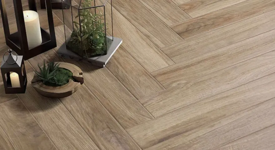 Sol en carrelage imitation bois, pose en chevron. Lanternes, bougies et plantes apportent une touche chaleureuse.