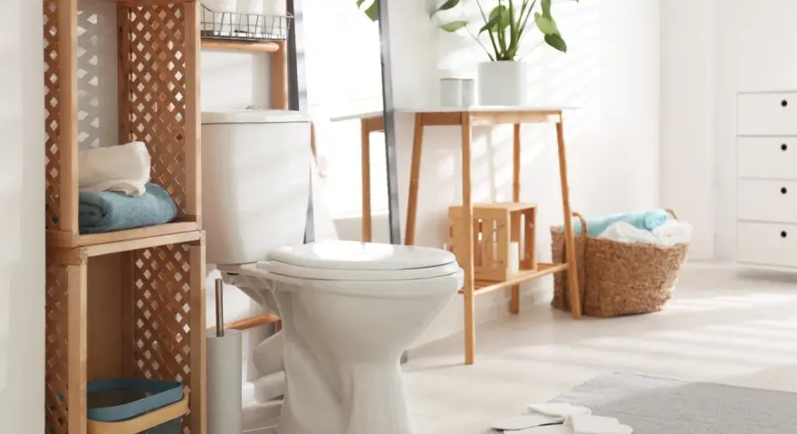 Toilette moderne et épurée, avec étagères en bois, paniers de linge et plantes vertes. Un style toilette invitant et fonctionnel.