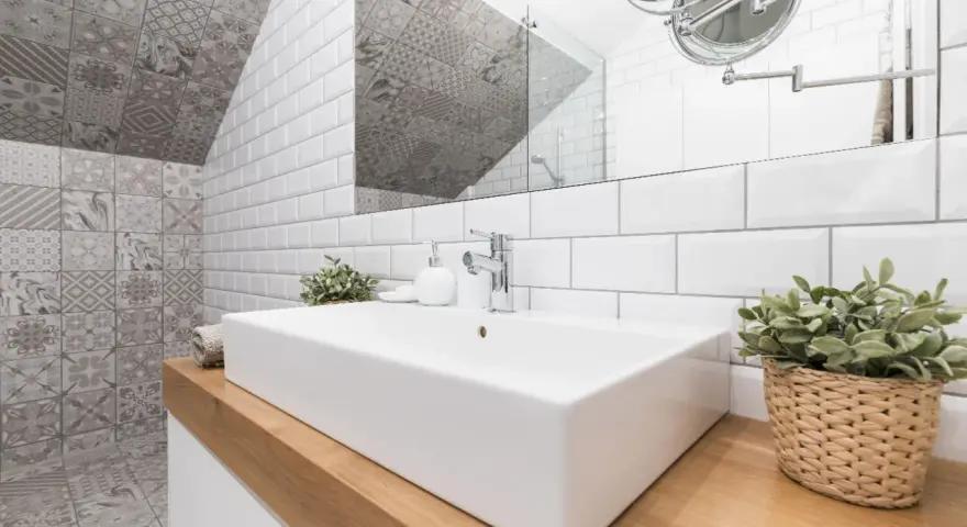 Une salle de bain moderne avec un lavabo rectangulaire blanc, un mur de carrelage métro blanc et un mur de carrelage décoratif gris. Une belle idée carrelage petite salle de bain.