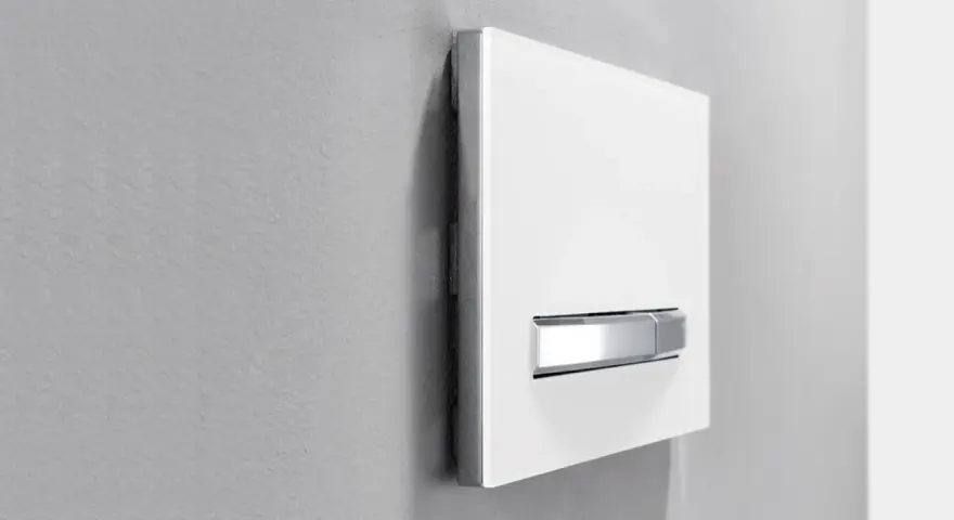 Plaque de déclenchement blanche avec double poussoir chromé pour une chasse d'eau à double débit, optimisant la consommation d'eau.