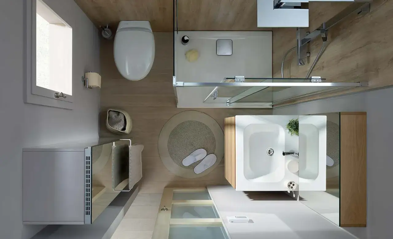 Vue aérienne d'une salle de bain en longueur : douche, lavabo, WC, et un radiateur. Ambiance boisée et moderne.