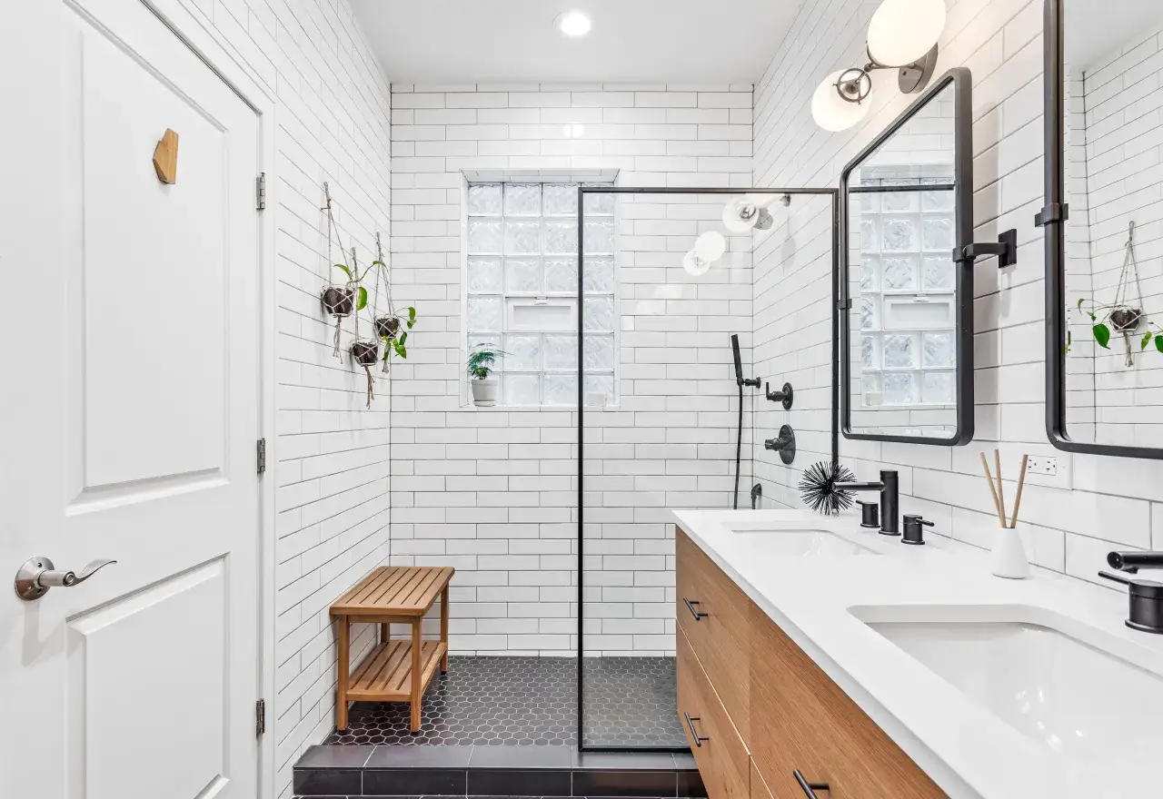 Salle de bain moderne avec deco wc noir et bois. Douche vitrée, double vasque, miroir, et banc en bois.