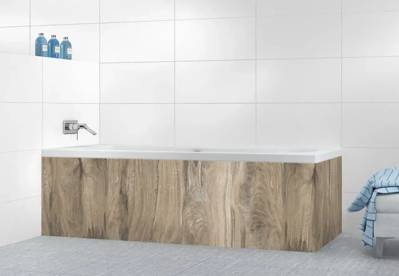 Une baignoire moderne avec un habillage imitation bois, une robinetterie chrom&eacute;e et des bouteilles de gel douche bleues. Id&eacute;e pour comment habiller une baignoire.