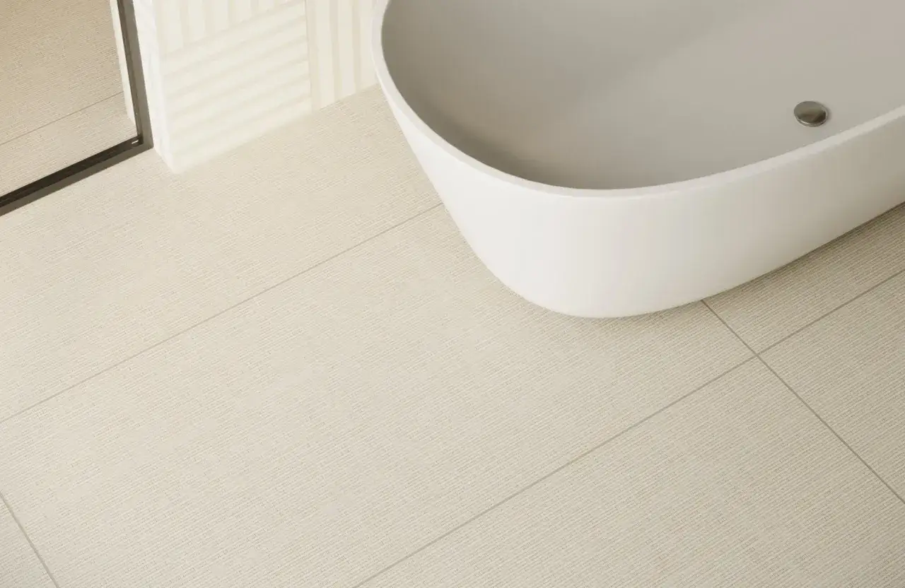 Bain blanc sur carrelage texturé beige. Le joint discret se fond parfaitement, une question de quelle couleur de joint pour carrelage beige ?