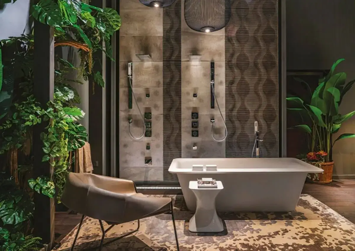 Salle de bain luxuriante avec baignoire &icirc;lot, deux douches murales et une chaise design. Une douche atypique, entour&eacute;e de v&eacute;g&eacute;tation tropicale.