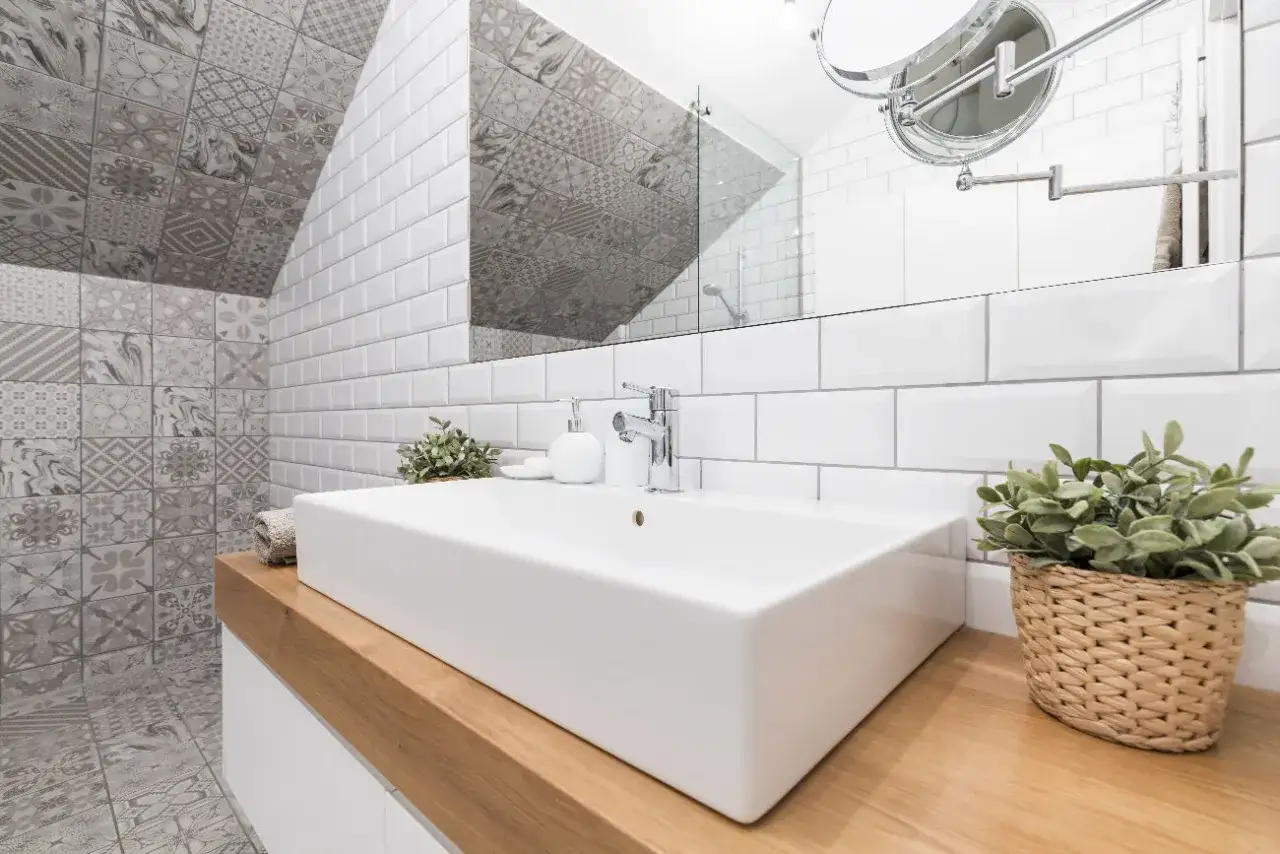 Salle de bain moderne avec un lavabo rectangulaire blanc, robinetterie chromée et une pose de faience murale originale.
