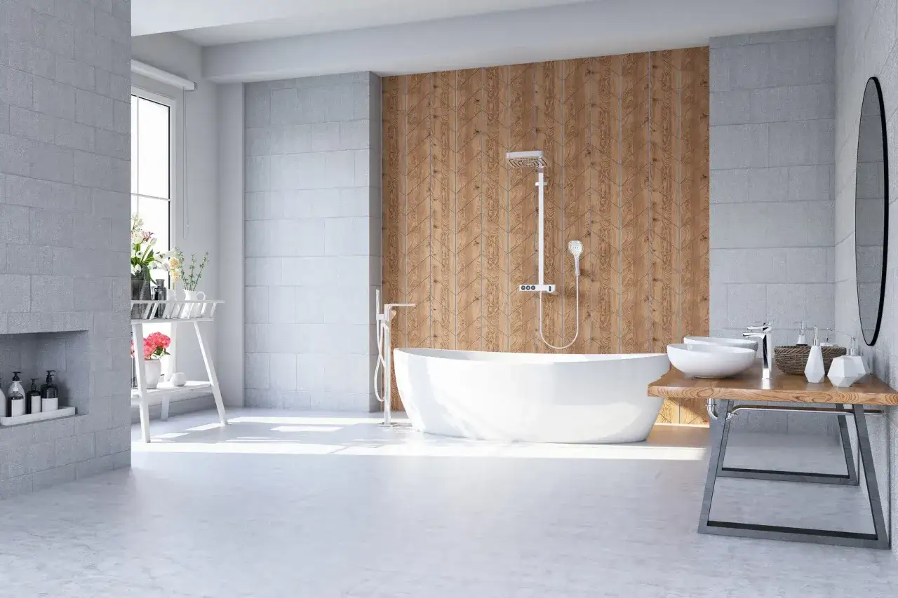 Salle de bain moderne avec baignoire îlot, murs en carrelage gris et lambris bois. Le sol PMR est lisse et clair, reflétant la lumière.