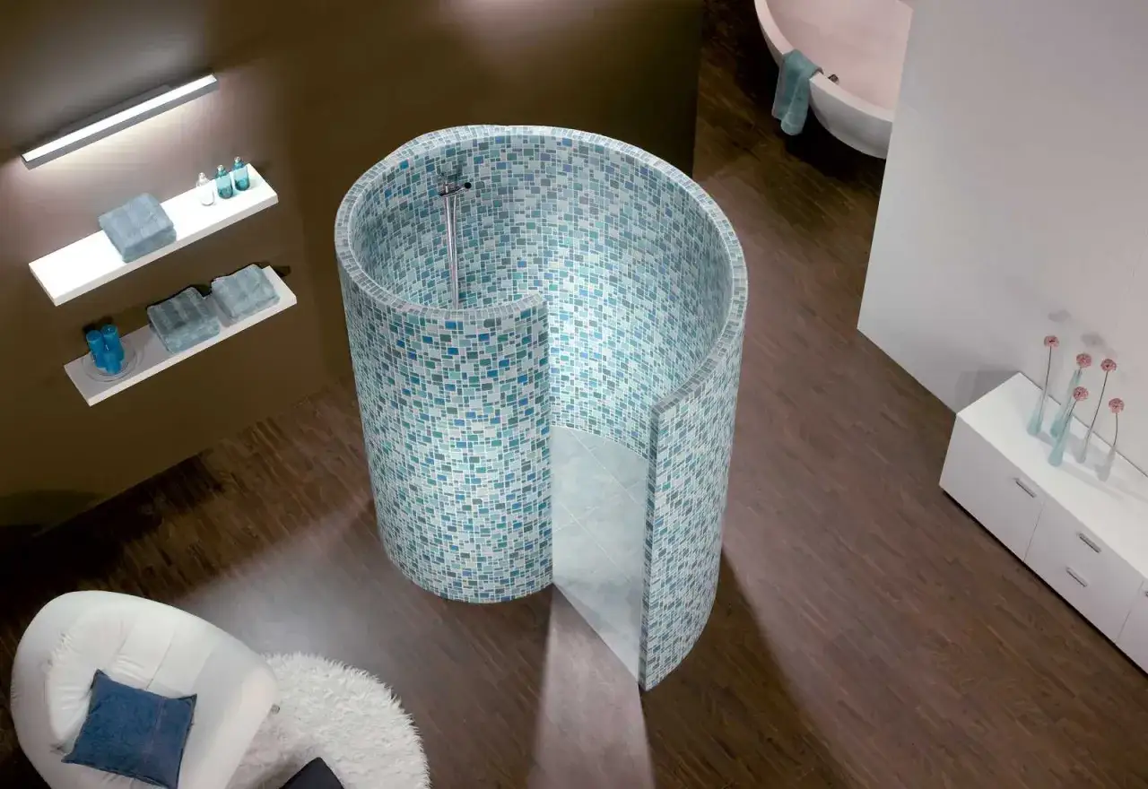 Une douche escargot unique, habillée de mosaïques bleues et vertes, invite à la détente dans cette salle de bain moderne.