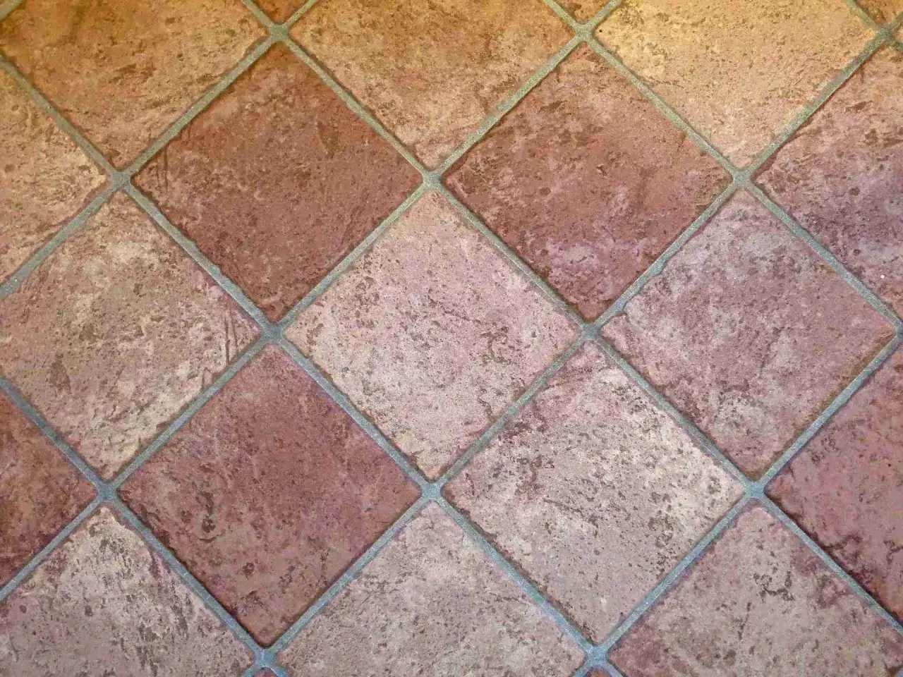 Carrelage mal posé, les carreaux de terre cuite sont de travers, créant un motif irrégulier et peu esthétique.