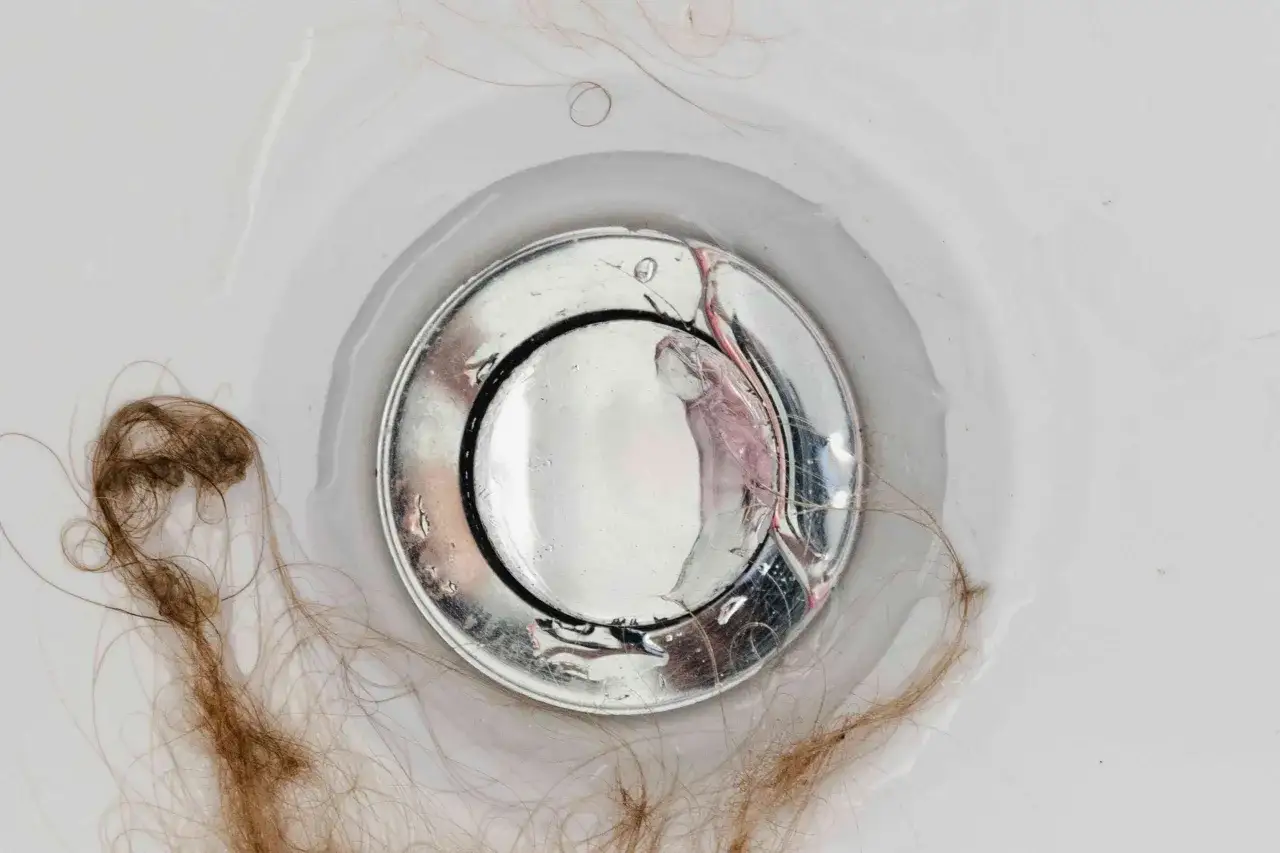 Cheveux dans le siphon de douche, signe d'une mauvaise odeur douche.