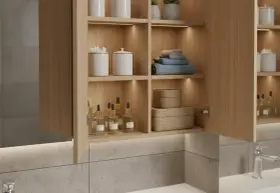 Belle idée rangement salle de bain : étagères en bois clair avec produits, serviettes et paniers tressés.