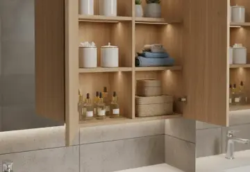 Belle idée rangement salle de bain : étagères en bois clair avec produits, serviettes et paniers tressés.