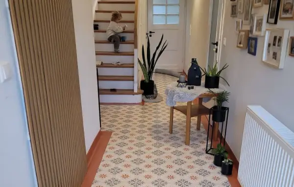 Un enfant sur les escaliers, un sol avec une peinture carrelage aux motifs floraux. La durée de vie de ce revêtement est impressionnante.