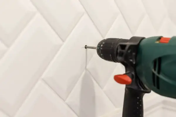 Une perceuse est utilisée pour percer le carrelage de la salle de bain.